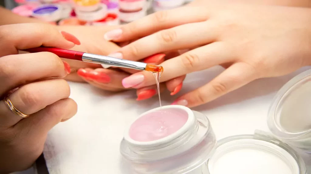 Manicure aplicando gel para unhas em cliente