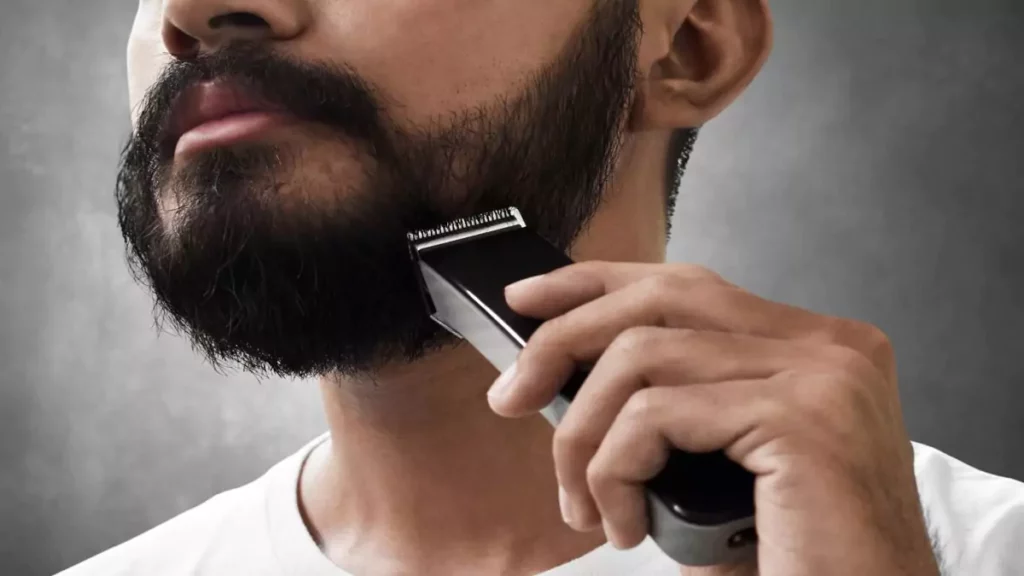Homem desenhando o rosto com aparador de barba